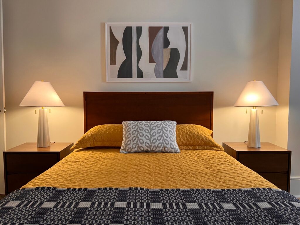 Full-size bed in a model bedroom at Baker House